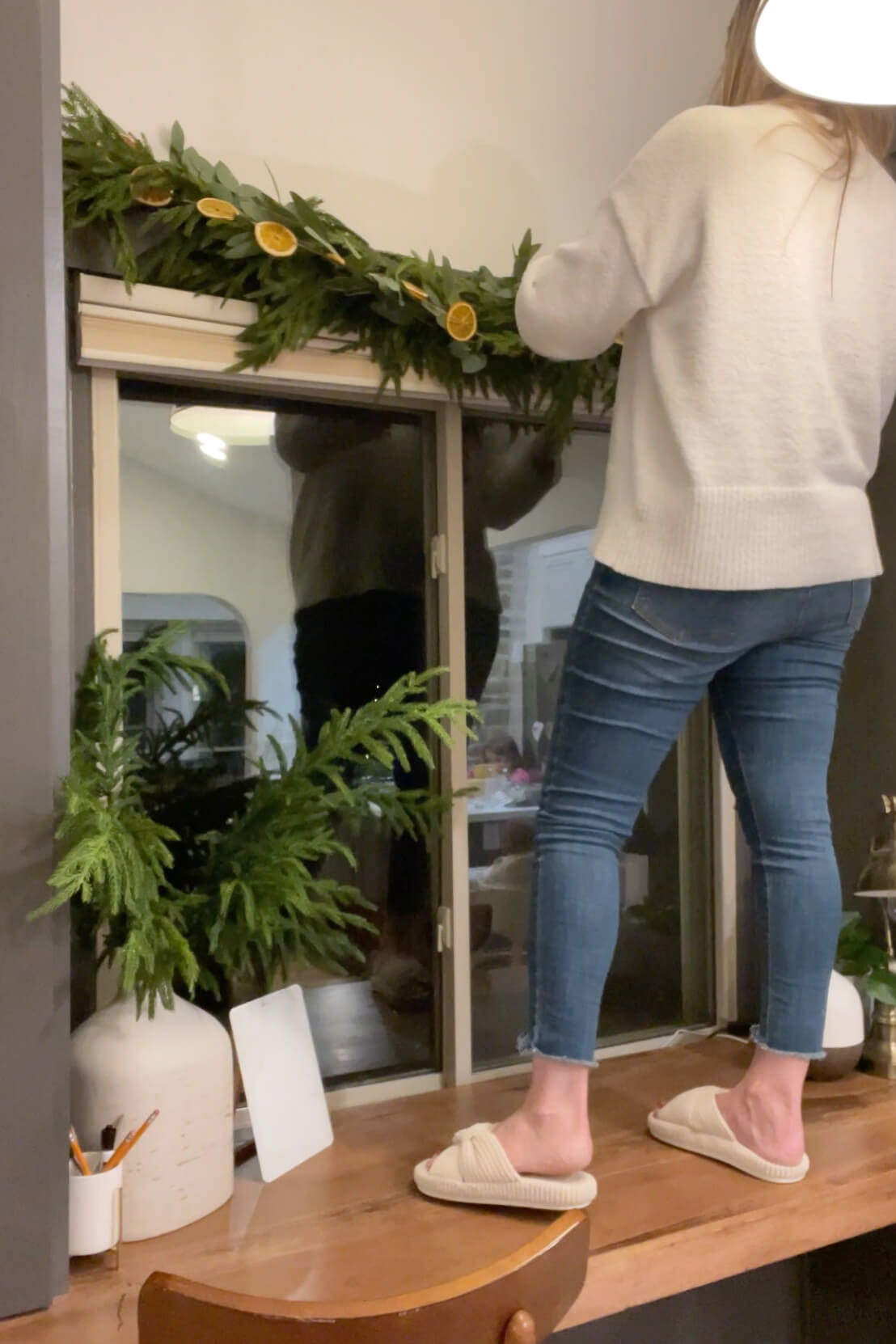 Hanging an orange slice garland above a window.